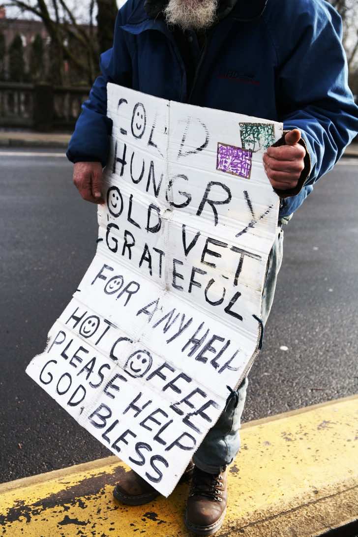 A homeless vet holding a sign for help.